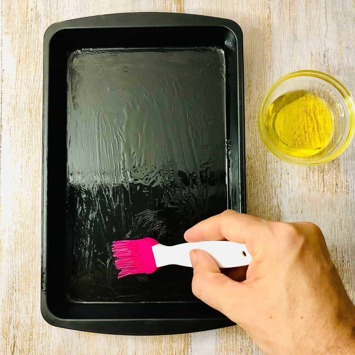 oiling a baking tray with a small brush