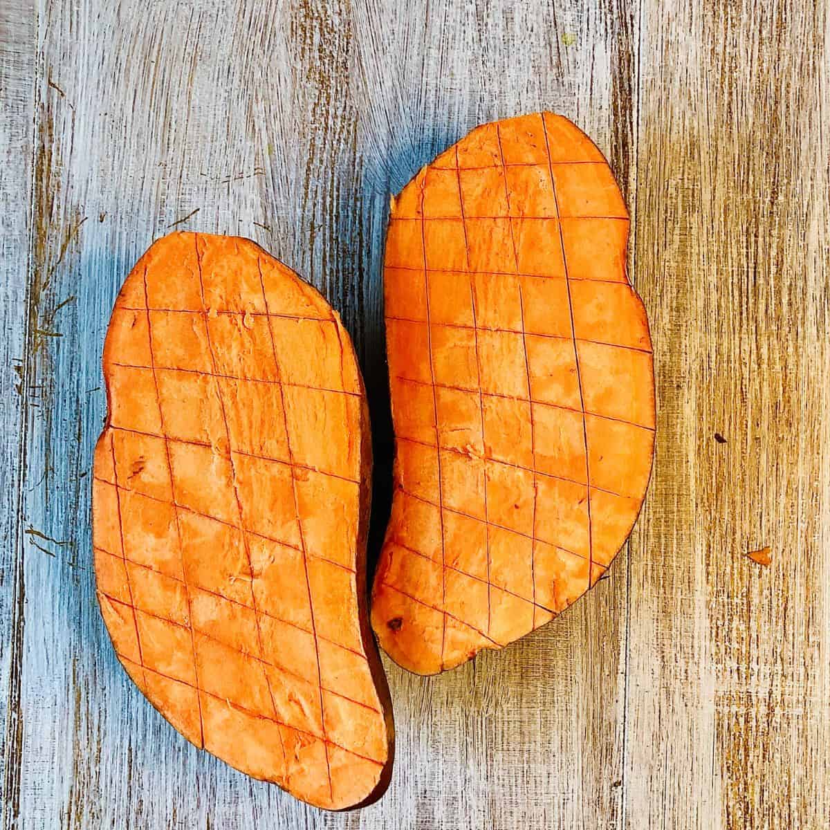 Sweet potato cut in half lengthwise and scored vertically and horizontally.
