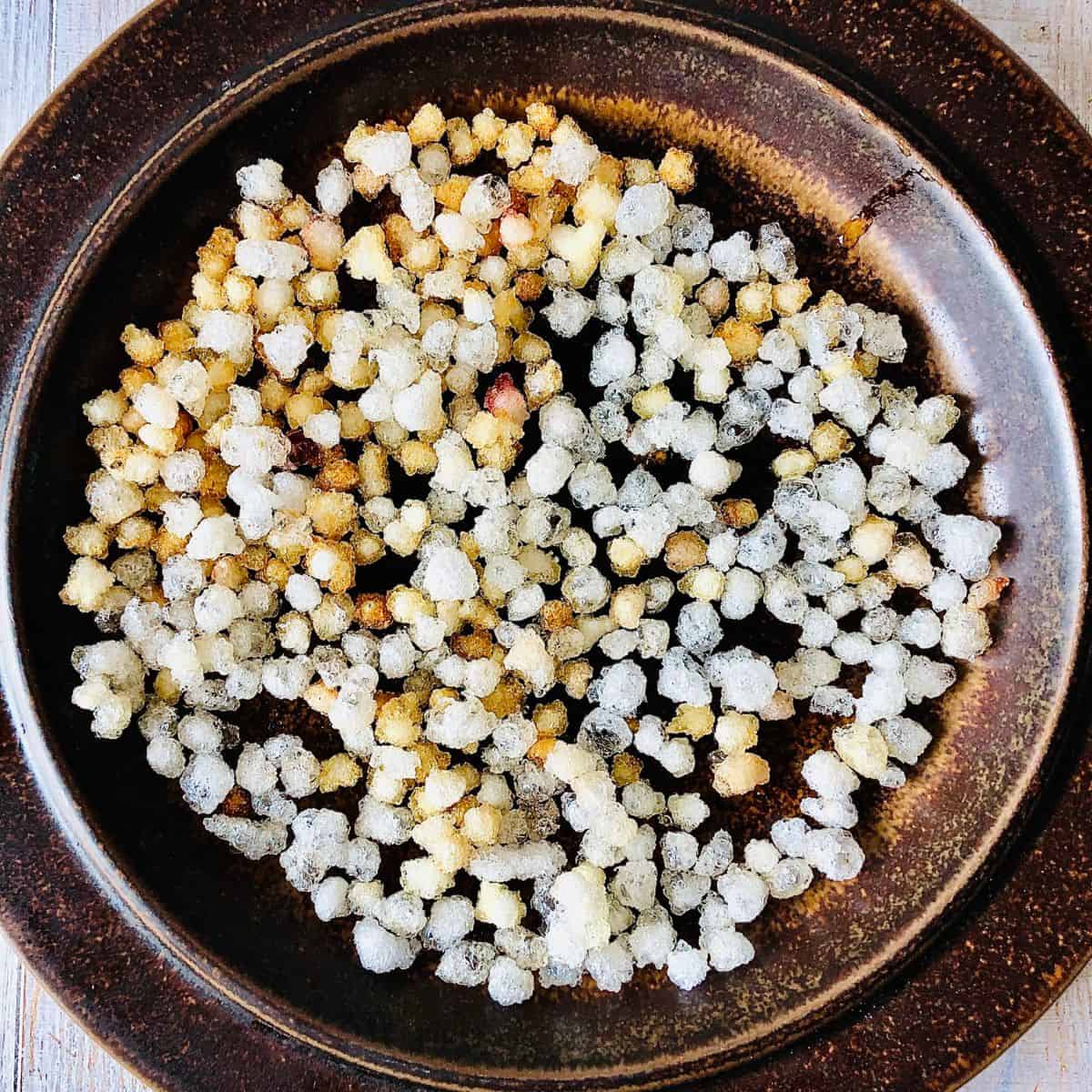 Gondh edible gum on a plate after frying. Golden brown colour.