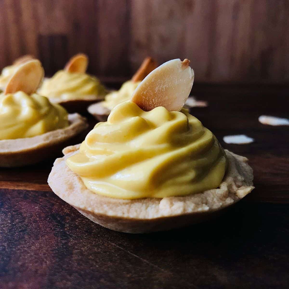 Close up of a Mango Shrikhand tart topped with an almond flake.