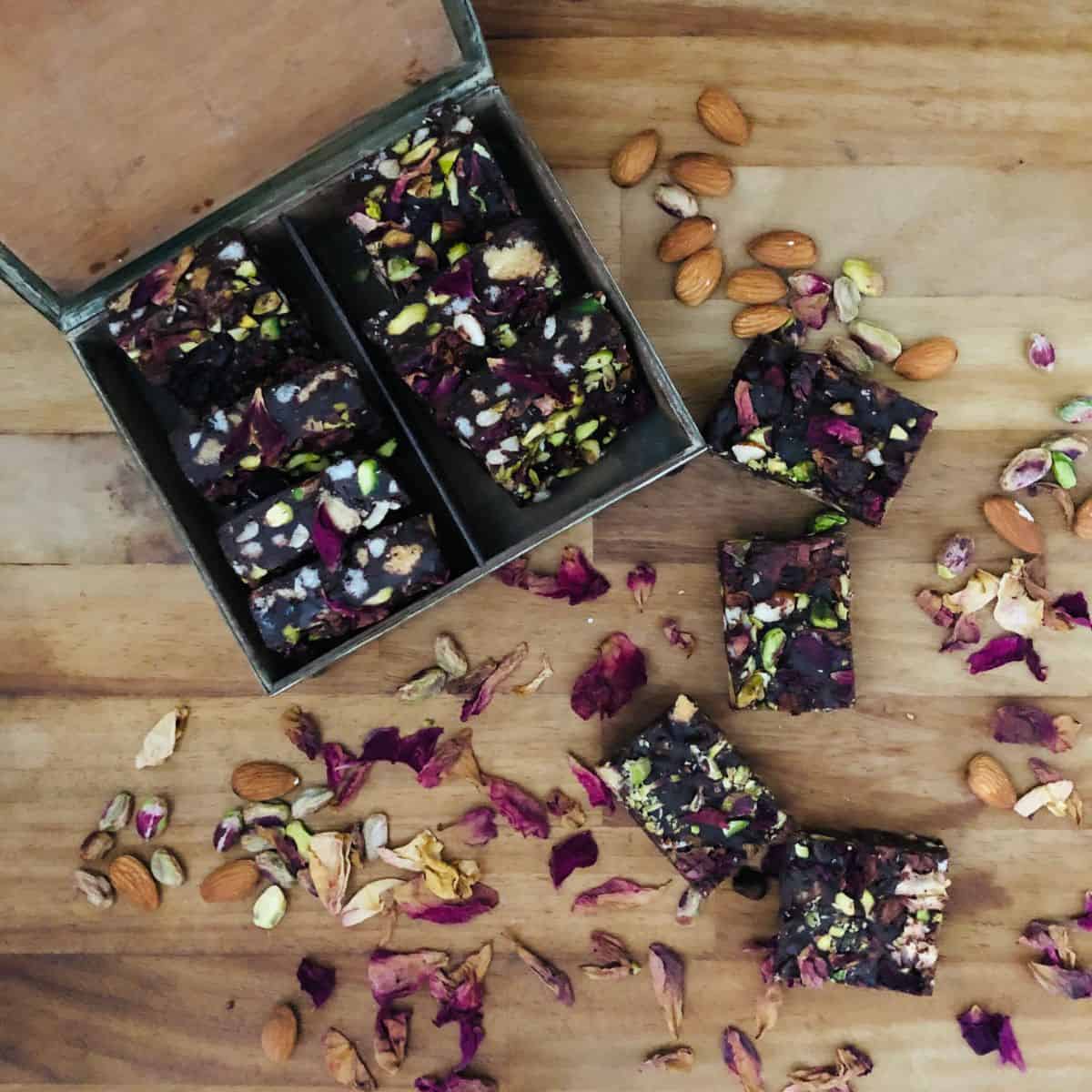Slices of rocky road on a wooden chopping board and in a small metal box.