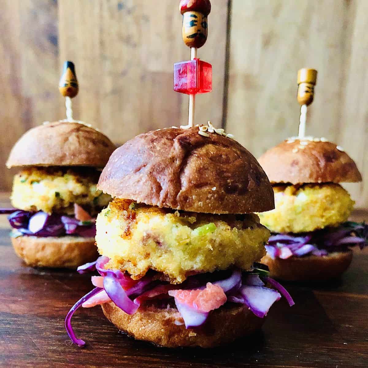 Close up of three dahi ke kabab mini vegan burgers. One at the front and two behind.