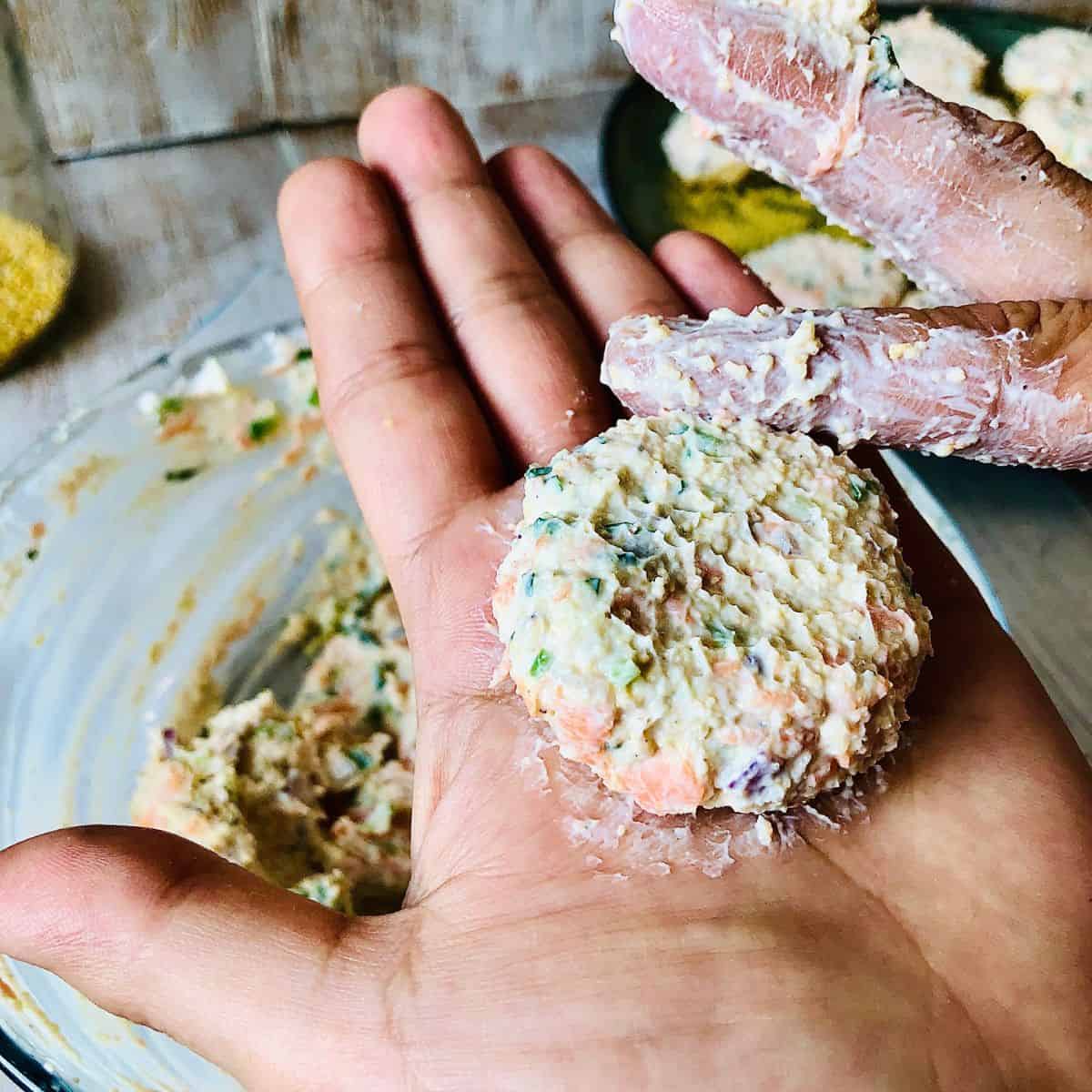 Dahi ke kabab mixture formed into a small patty in the palm of a hand.