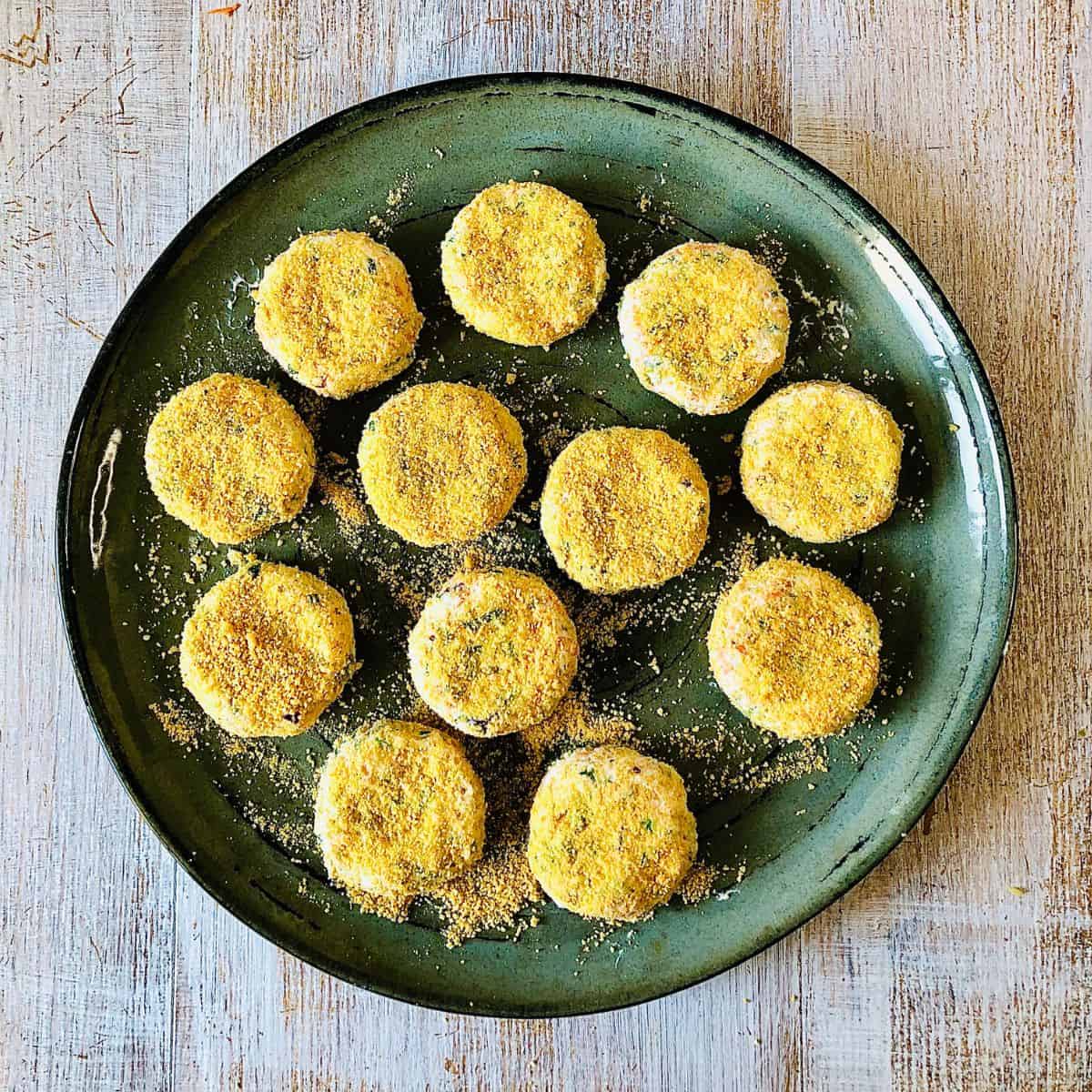 Dahi ke kabab patties coated in breadcrumbs in a frying pan, ready to shallow fry.