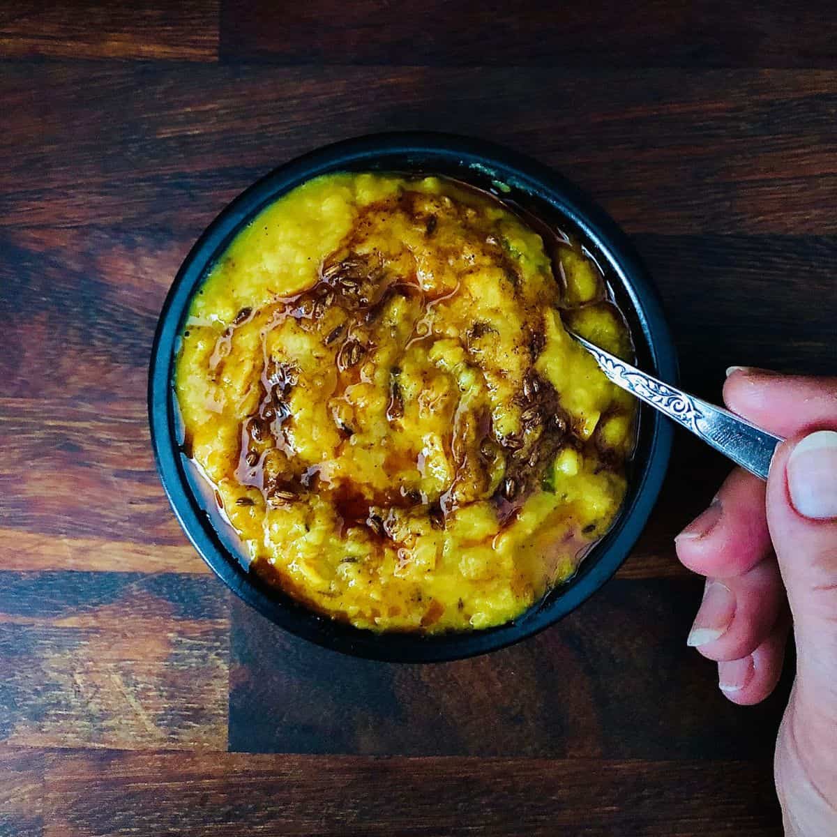 A shallow dish containing daal with tempered tadka.