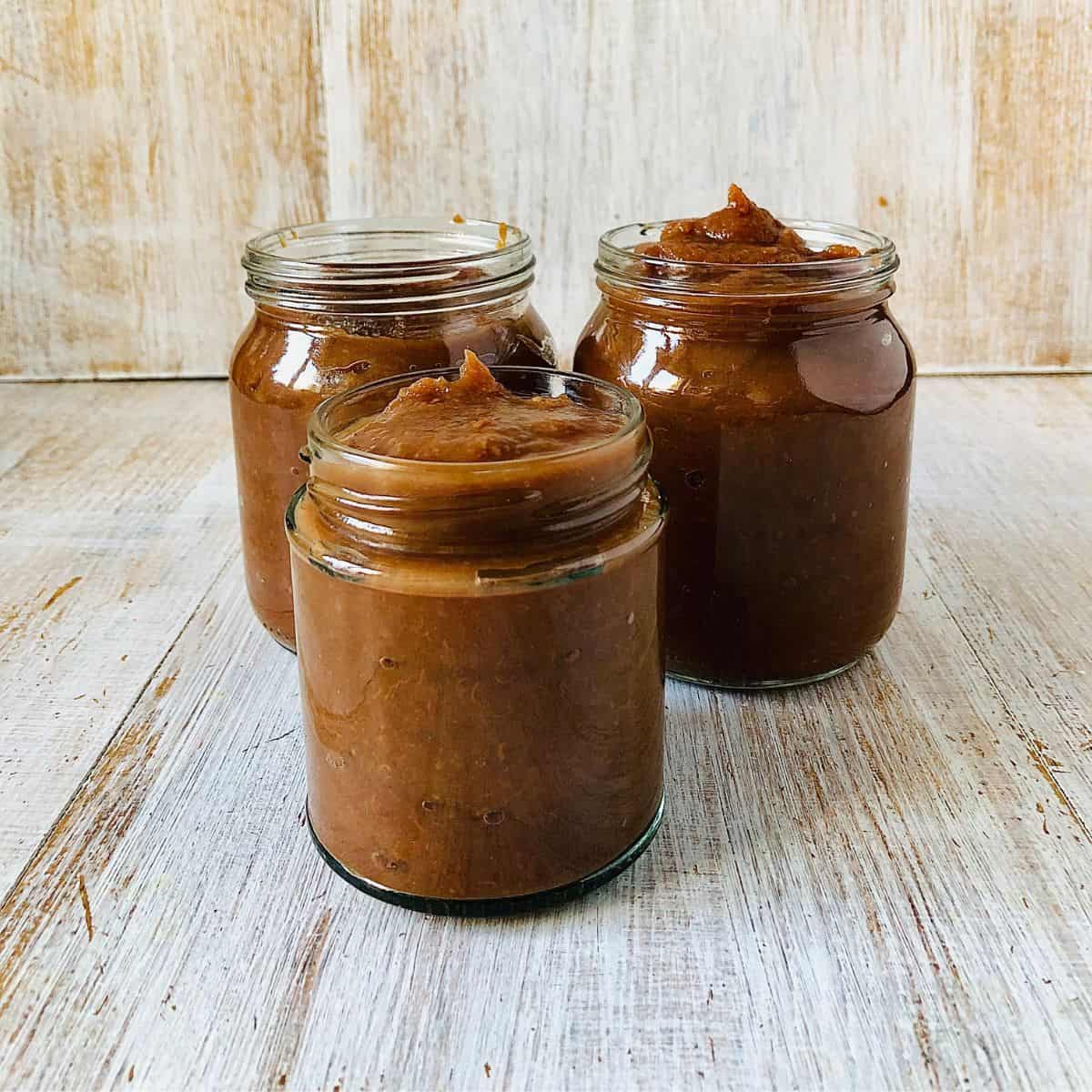 Close up of three jars containing medlar butter.