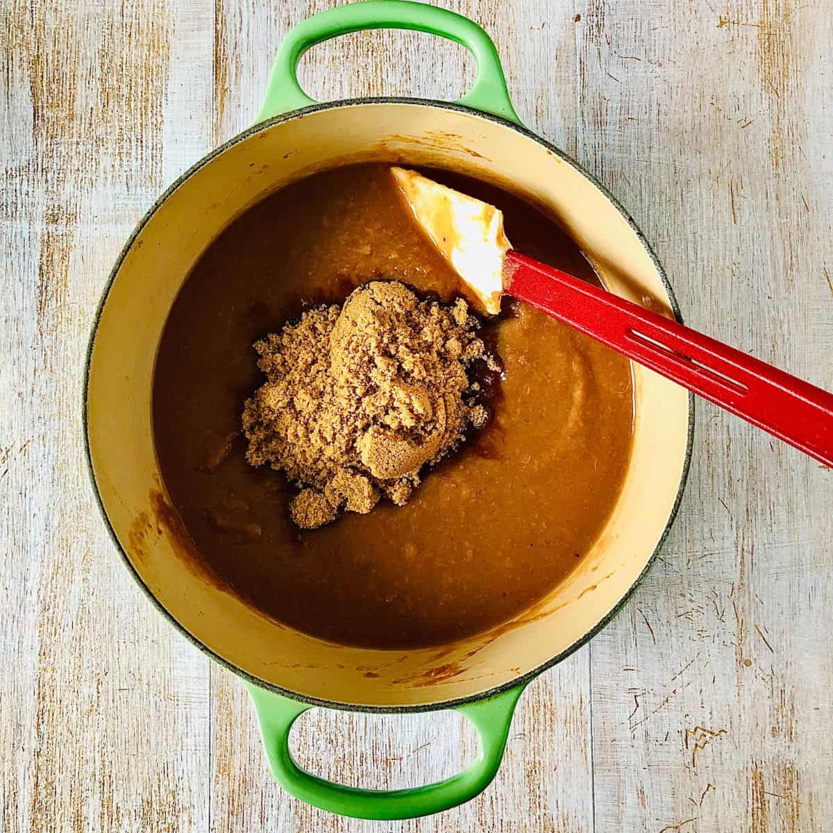 A large pan containing medlar puree with soft brown sugar added.