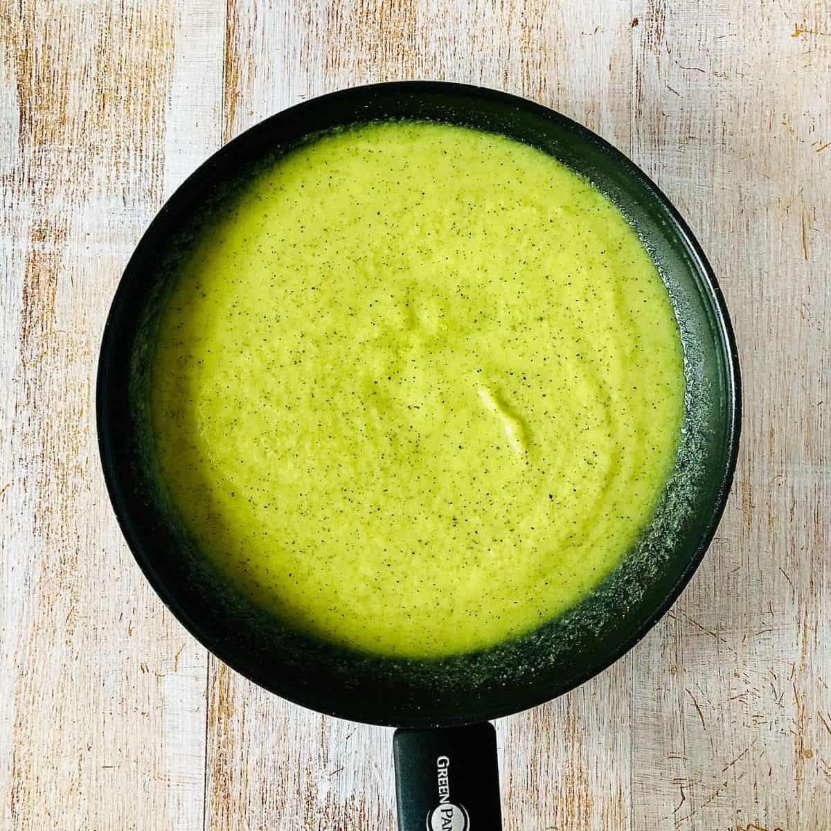 A frying pan contain courgette pasta sauce after blending ingredients.