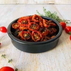 A shallow dish containing oven-dried cherry tomatoes.