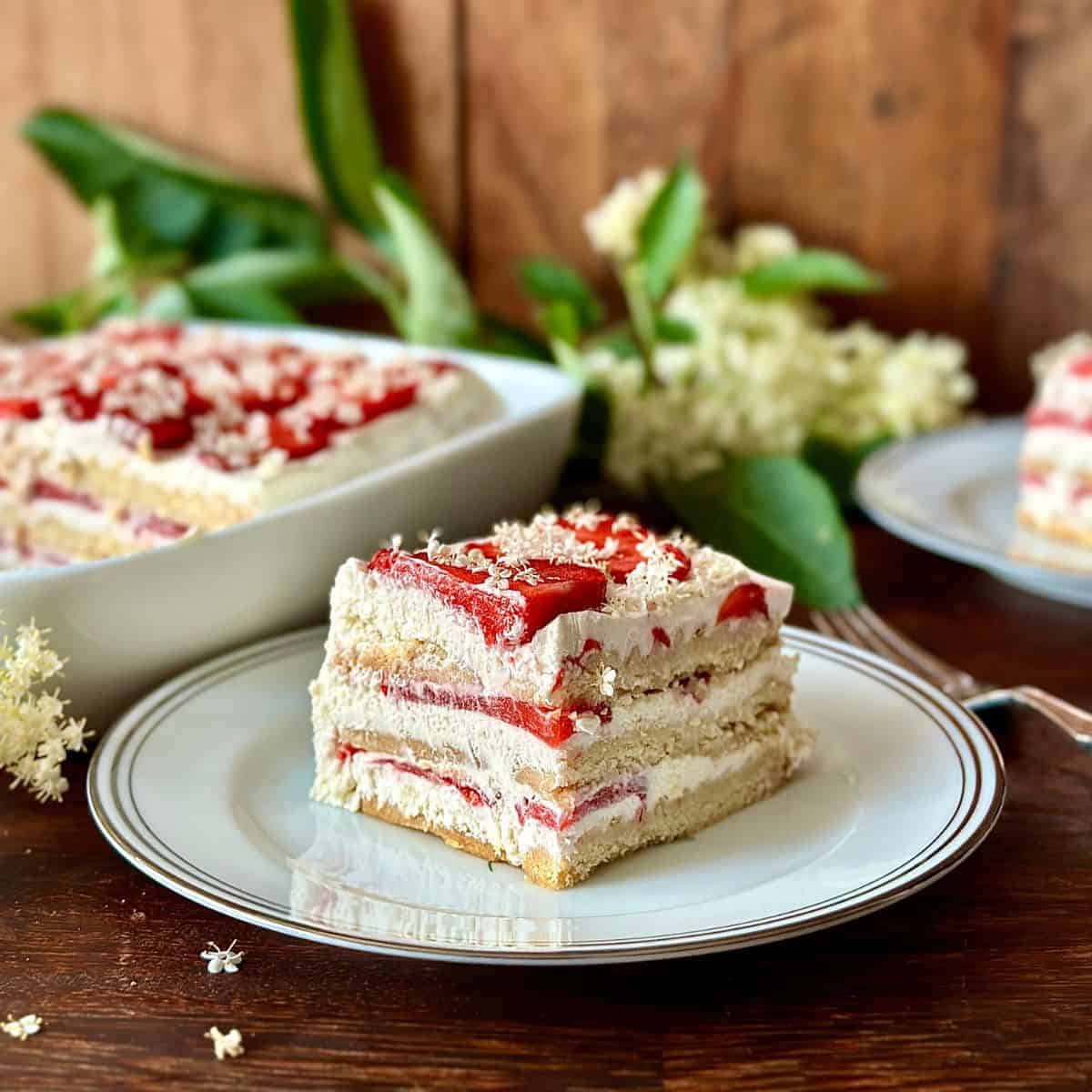 A slice of elderflower and strawberry cake on a small plate.