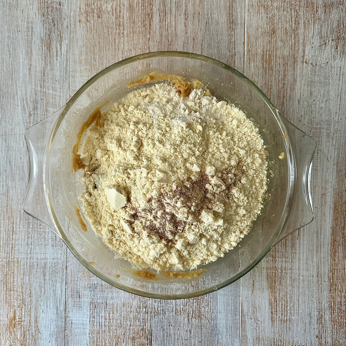 A glass dish containing dry ingredients for Gulab Jamun cookies.