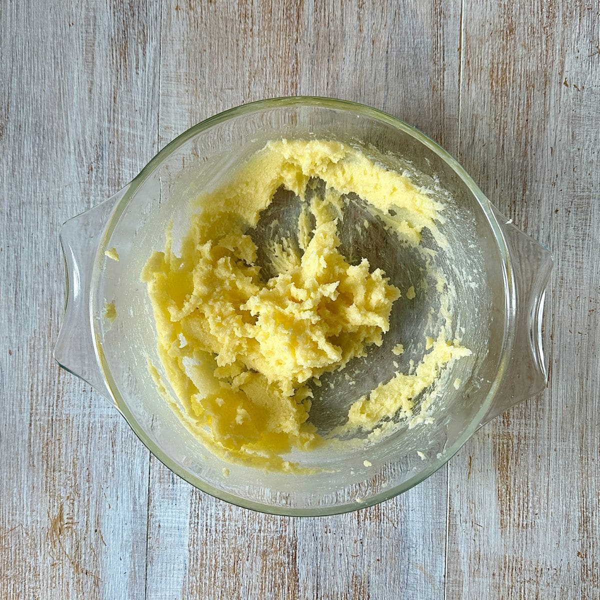 A glass dish containing creamed butter and sugar.