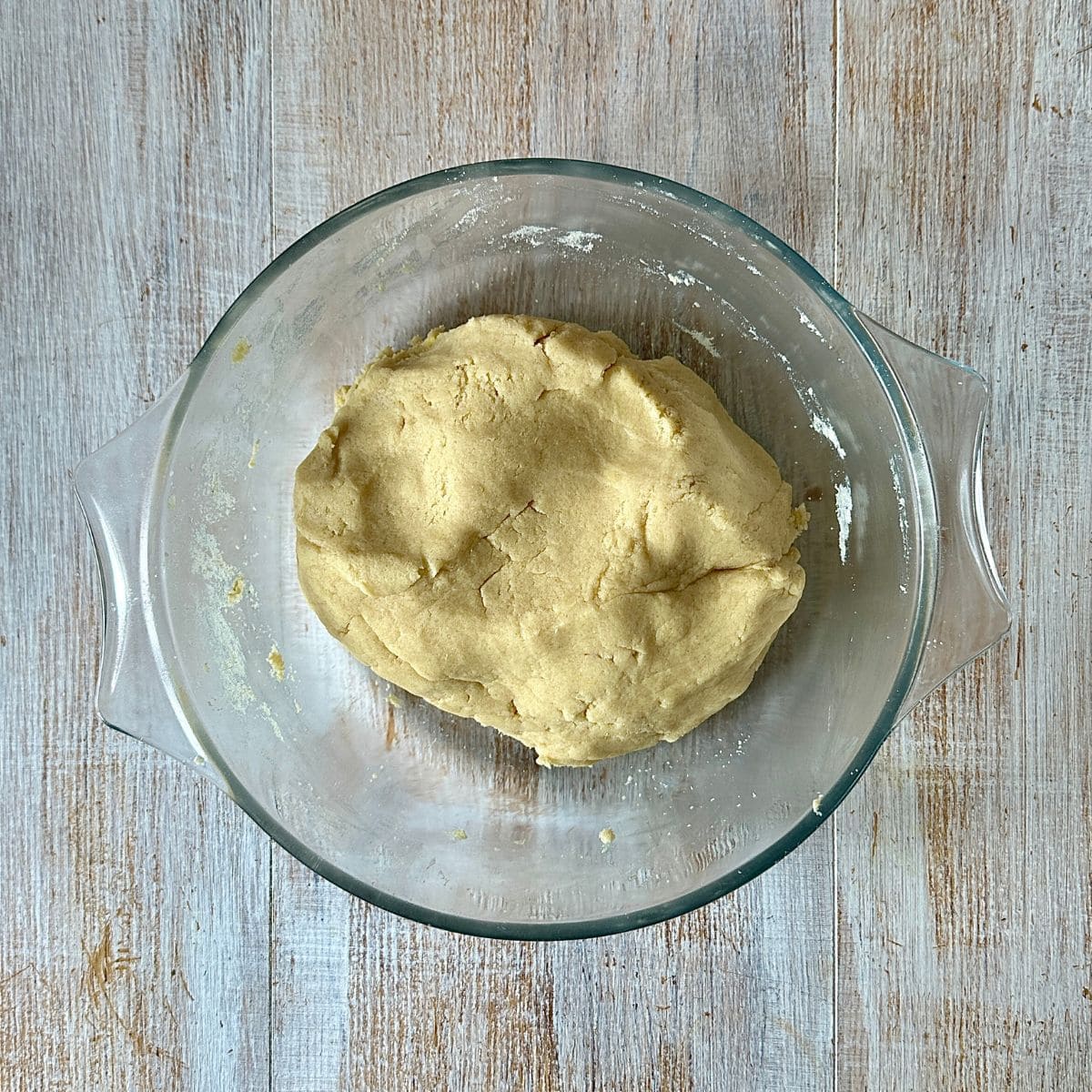 A glass dish containing dough for Gulab Jamun cookies.