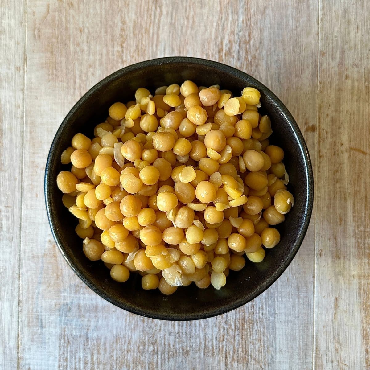 Overhead photo of a bowl of cooked yellow peas.