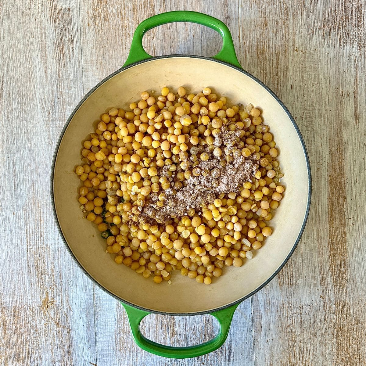 A large saucepan containing cooked yellow peas, karla namak and coriander powder.