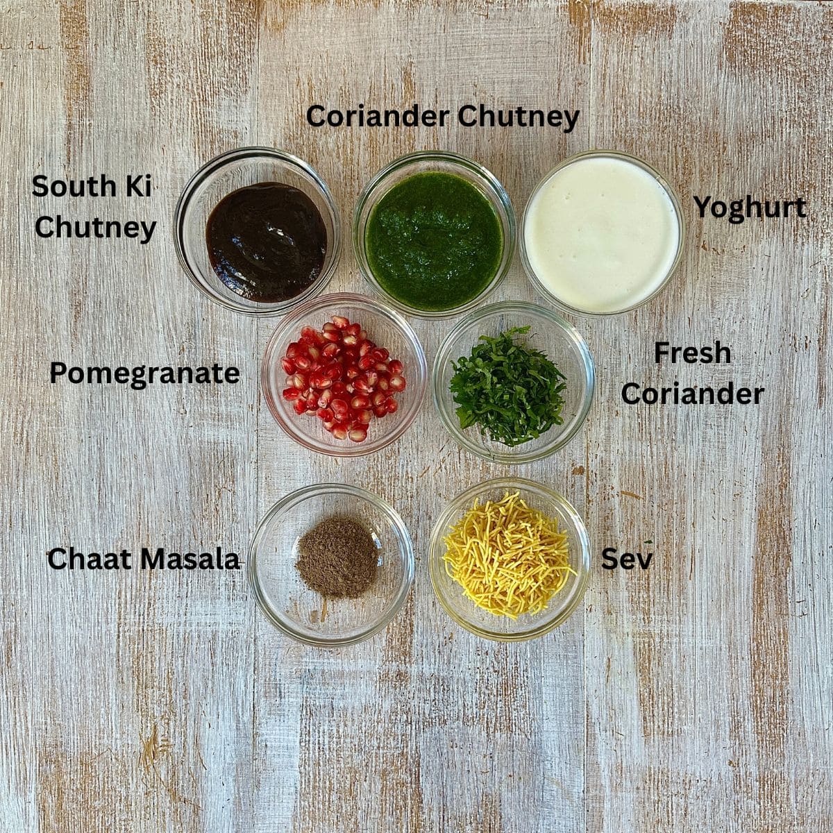 Prepared ingredients for the garnish of matar ki chaat in small glass dishes, annotated.