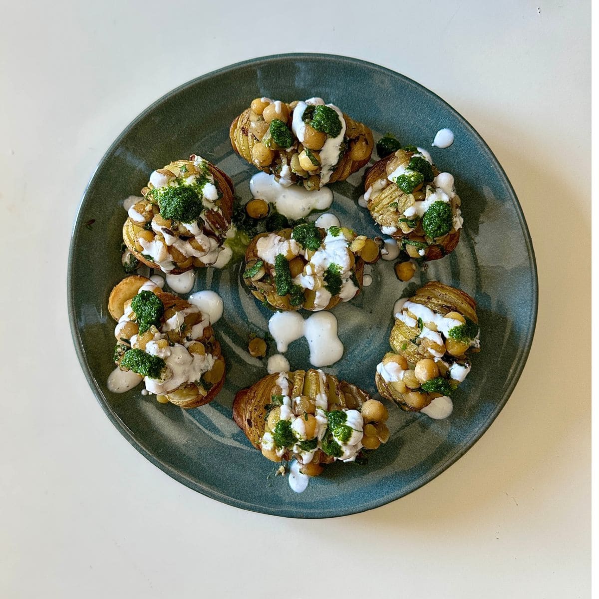A serving plate with seven hasselback potato matar ki chaat ready to serve.
