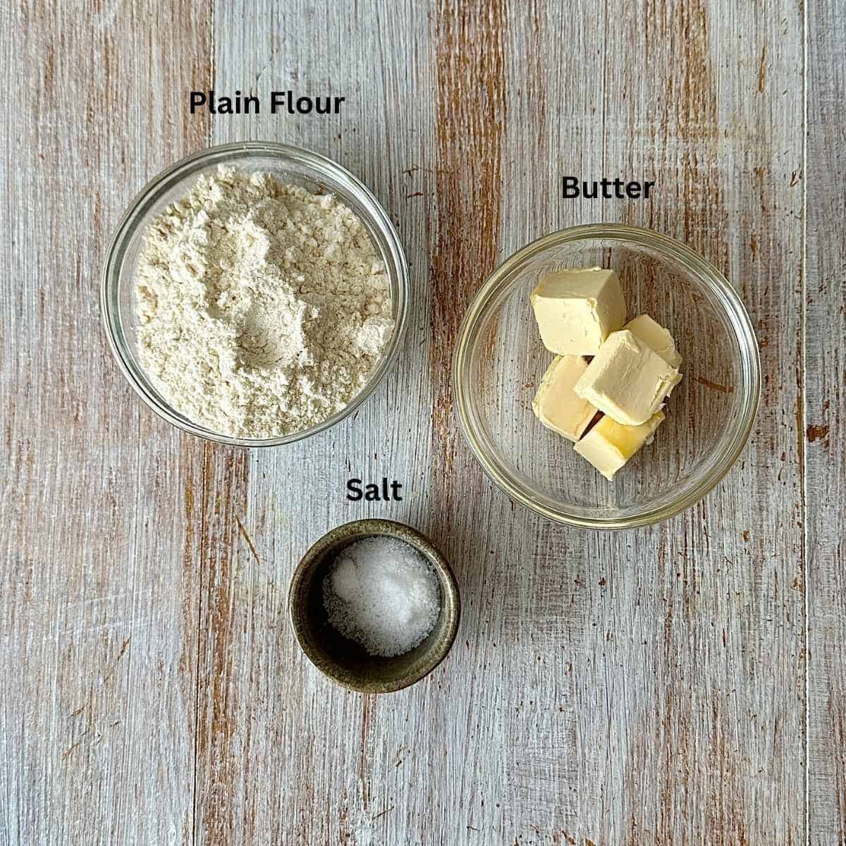 Prepared ingredients for pumpkin galette dough, in small glass and ceramic dishes.