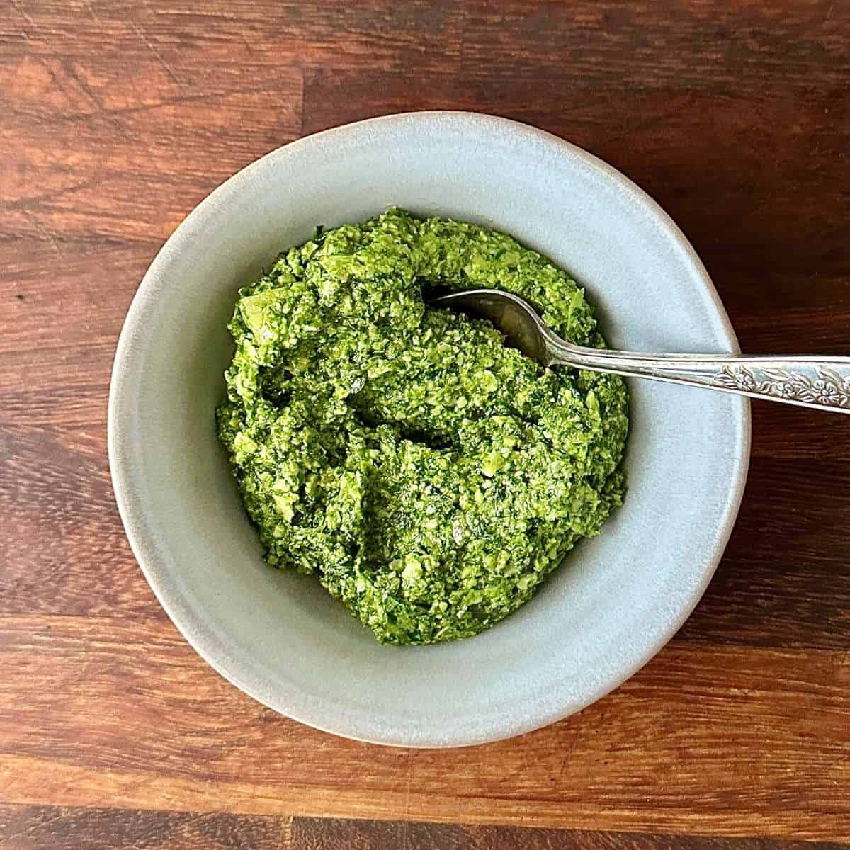 A small round ceramic bowl containing rocket pesto.