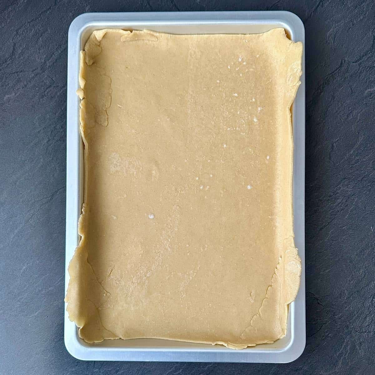 A baking tray containing pastry dough for pumpkin galette.