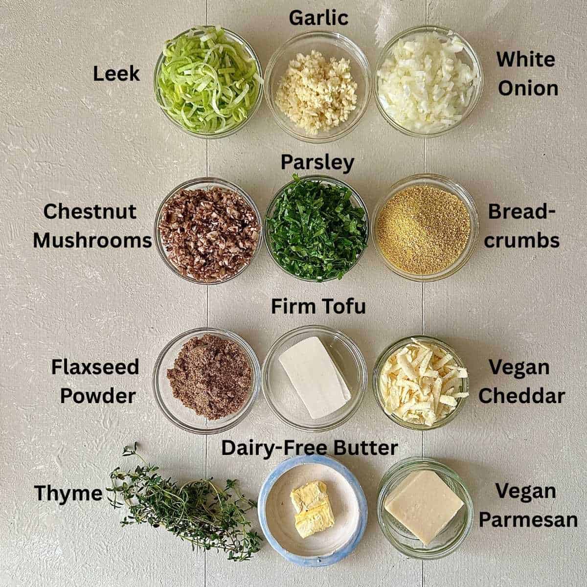 Prepared ingredients for leek and mushroom Christmas bake in small glass dishes. Annotated.