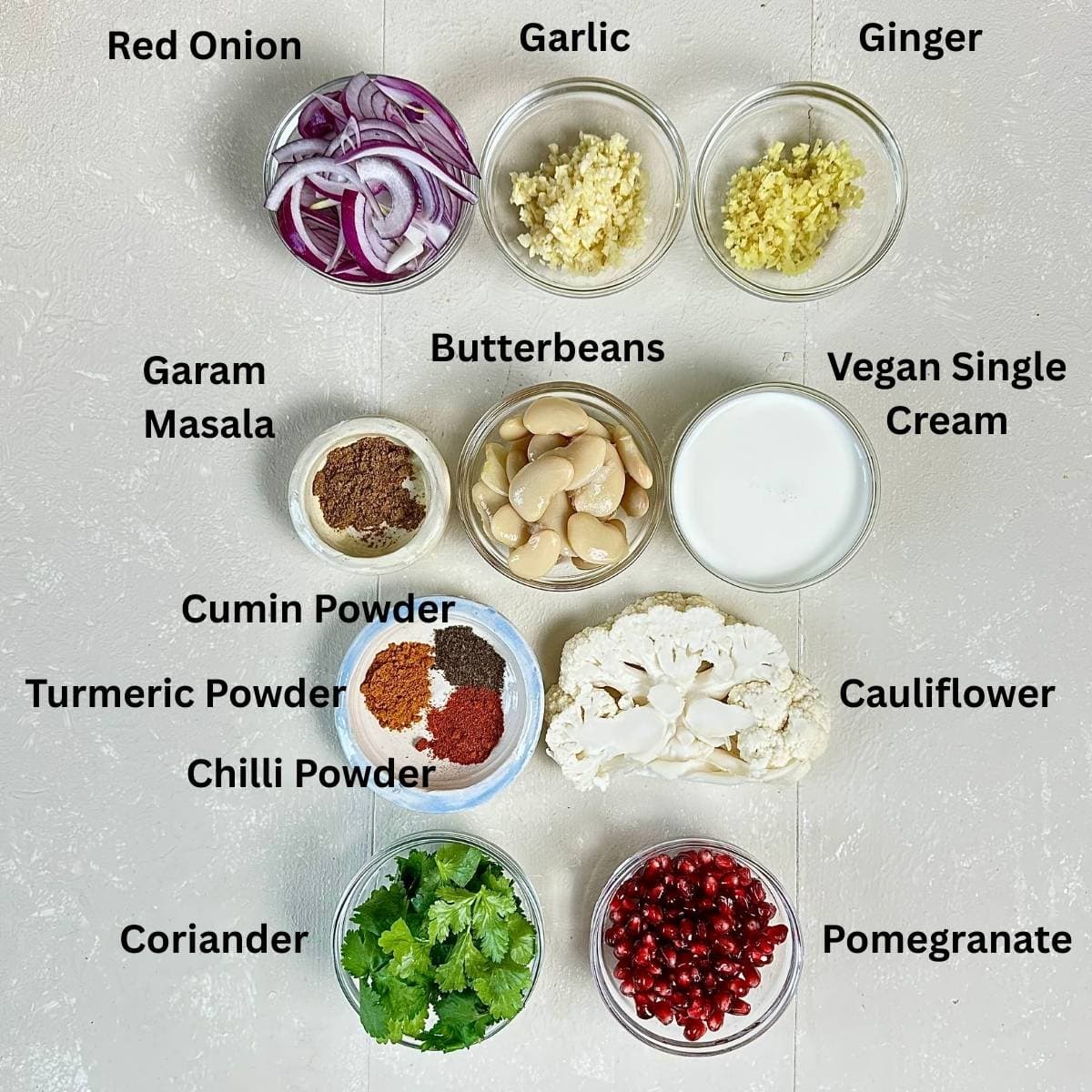 Prepared Ingredients for roasted cauliflower steaks and korma-style sauce in small glass dishes. Annotated.