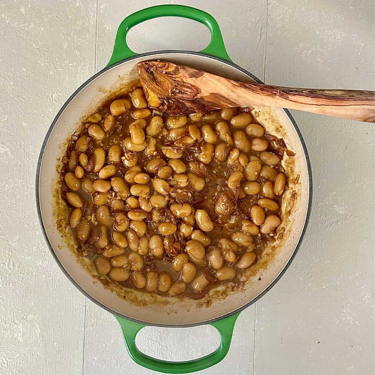 A large pot containing a cooked korma-style sauce with butterbeans, ready to blend together, for roasted cauliflower steaks in a korma-style sauce recipe