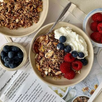 Homemade sugar free granola with almonds, seeds and popped amaranth in a bowl with yoghurt and fresh berries.