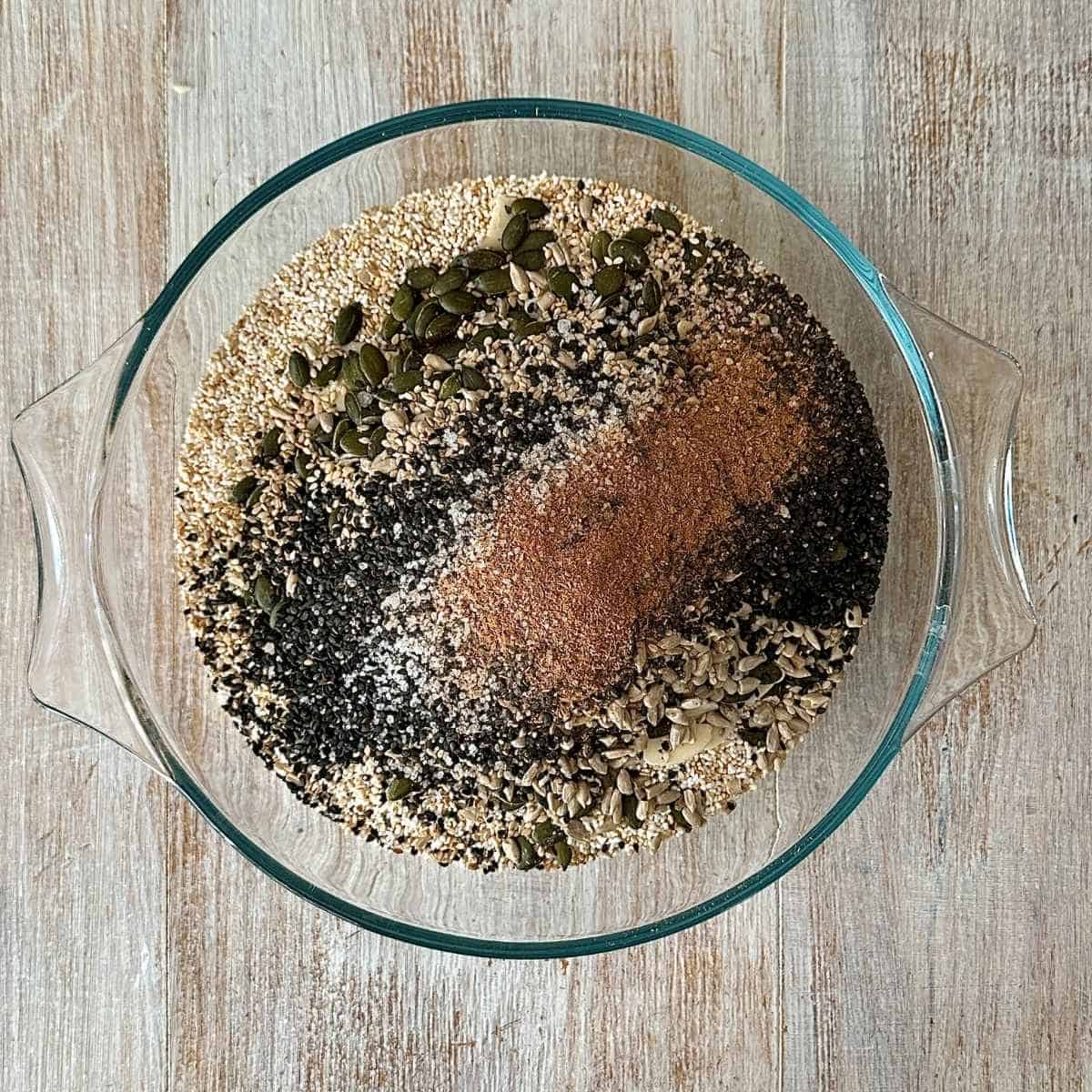 Dry ingredients for sugar free granola mixed together in a large glass bowl.