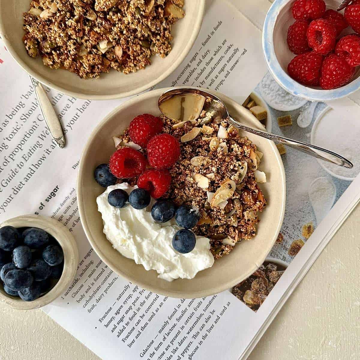 Sugar free granola with nuts, seeds and popped amaranth served with yoghurt and fresh berries in a bowl.