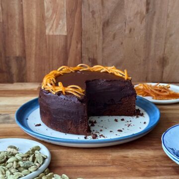 Side view of a dark chocolate mud cake with ganache, showing dense fudgy texture in a single layer cake