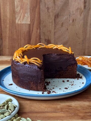 Side view of a dark chocolate mud cake with ganache, showing dense fudgy texture in a single layer cake