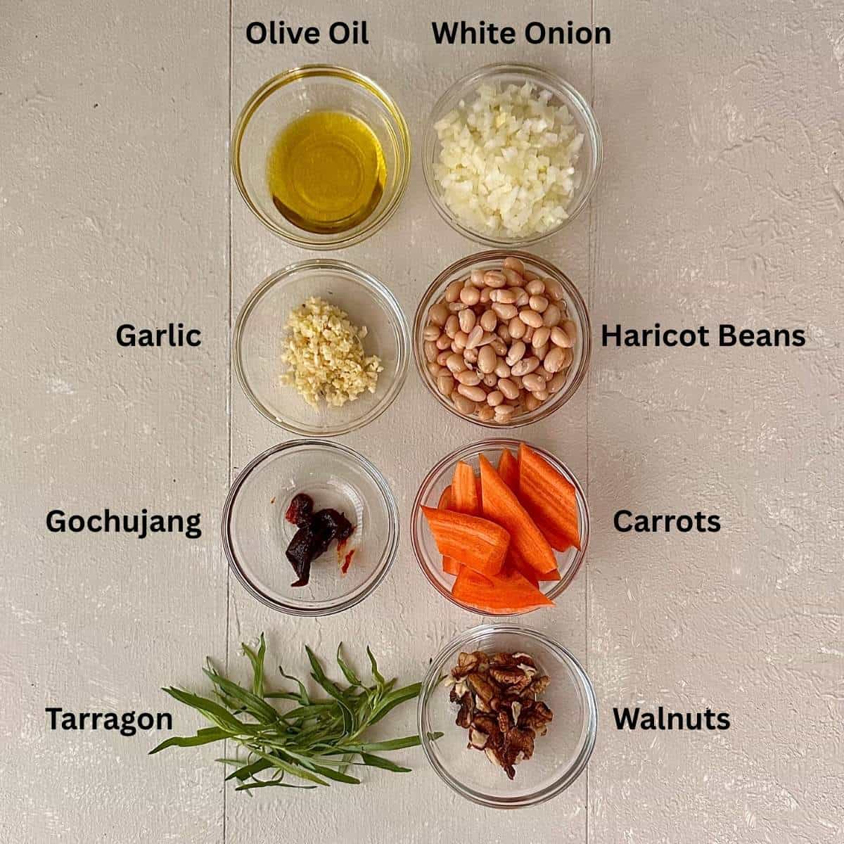 Prepared ingredients for gochujang roasted carrots in small glass dishes. The ingredients are annotated.