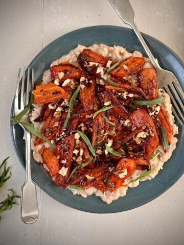 Spicy gochujang roasted carrots with creamy white beans, a plant-based main or side dish