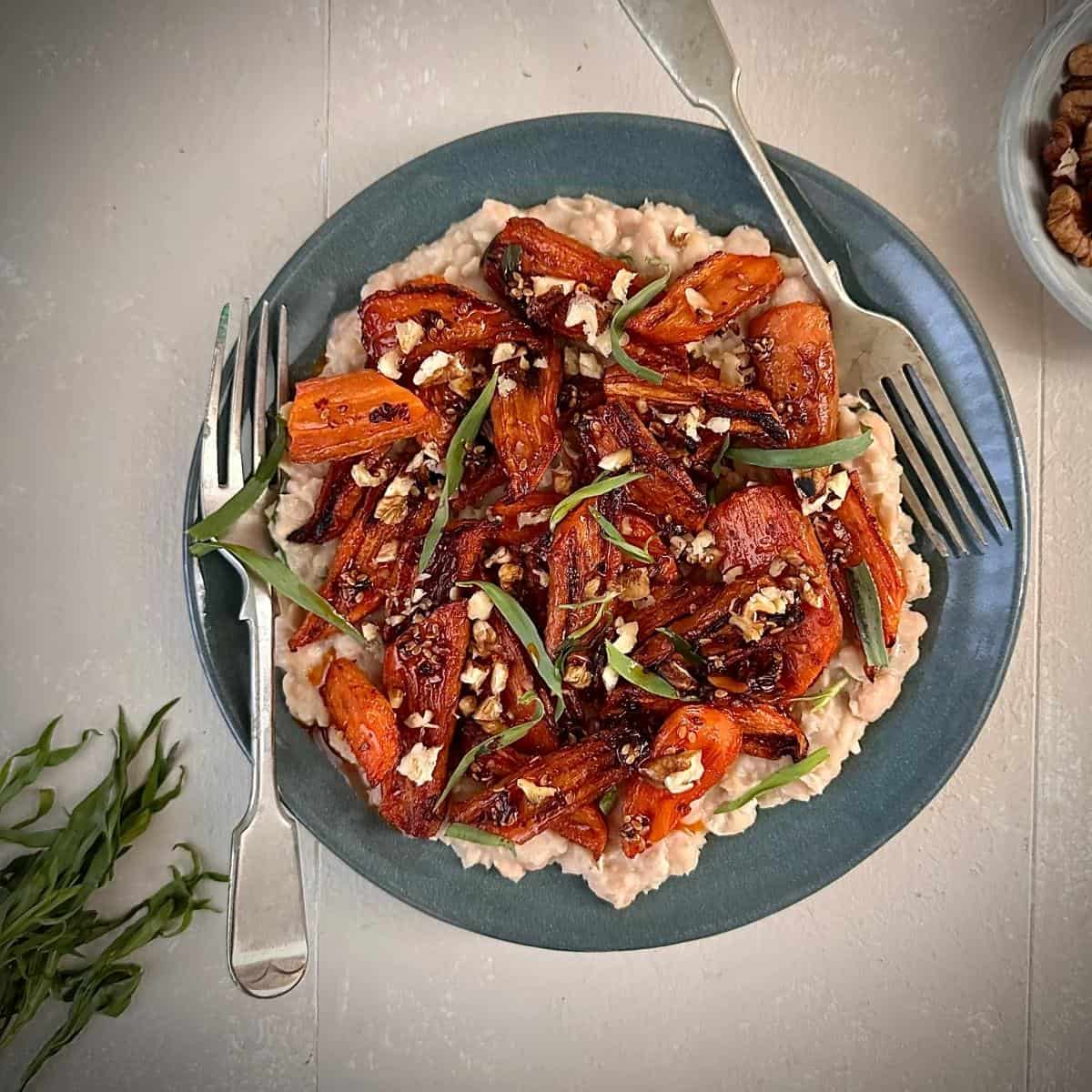 Spicy gochujang roasted carrots with creamy white beans, a plant-based main or side dish