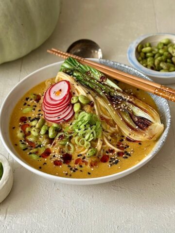 Vegetarian veggie ramen in a rich pumpkin and miso broth with noodles and greens.
