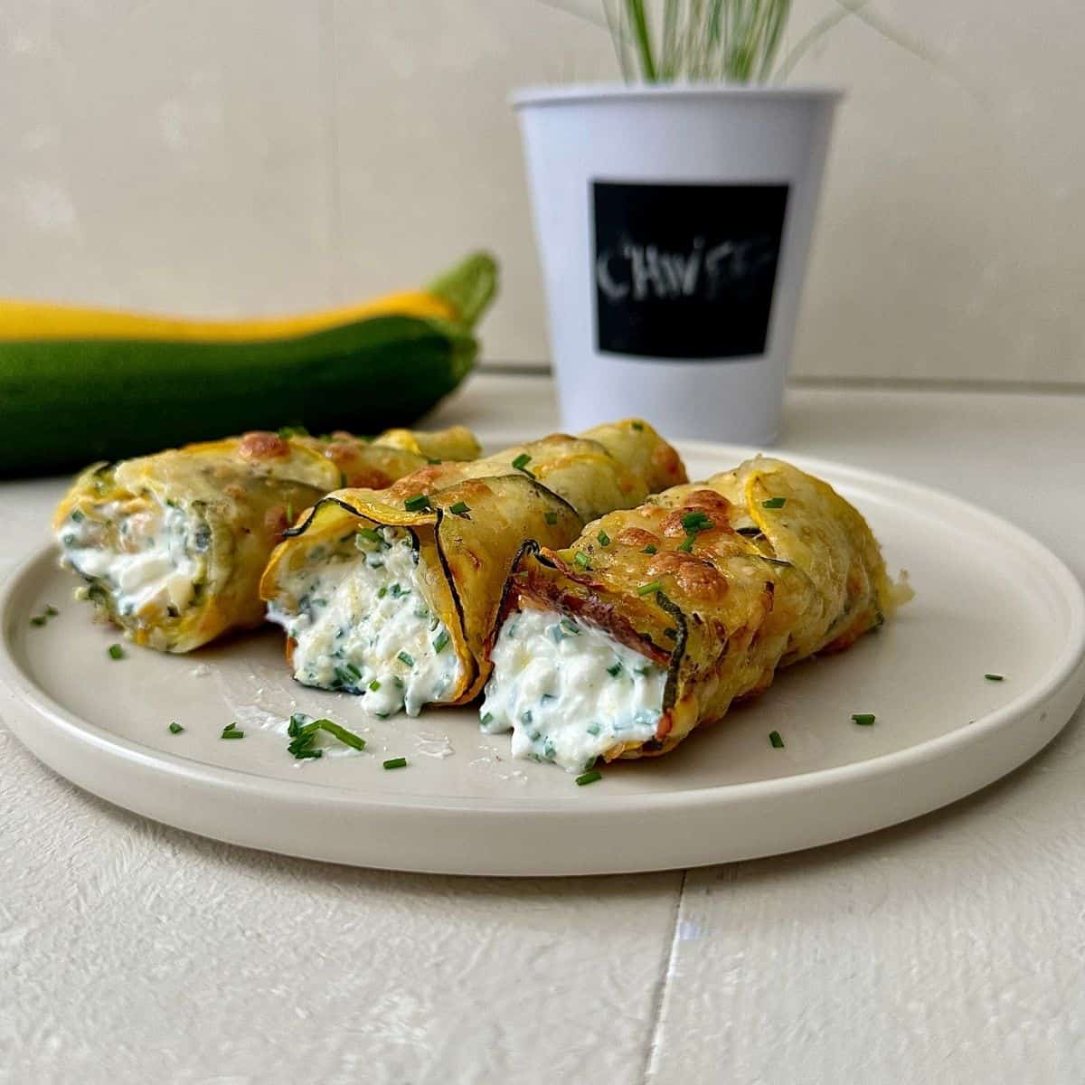 Low carb cottage cheese wrap with courgette base and chive filling on a beige plate.