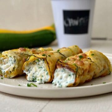low carb cottage cheese wrap with cheesy courgette base and chive filling on a beige plate.