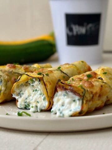 low carb cottage cheese wrap with cheesy courgette base and chive filling on a beige plate.