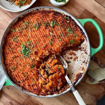 Sweet potato lentil shepherd's pie with golden mashed topping and herbs.