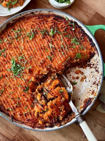 Sweet potato lentil shepherd’s pie with golden mashed topping and herbs.