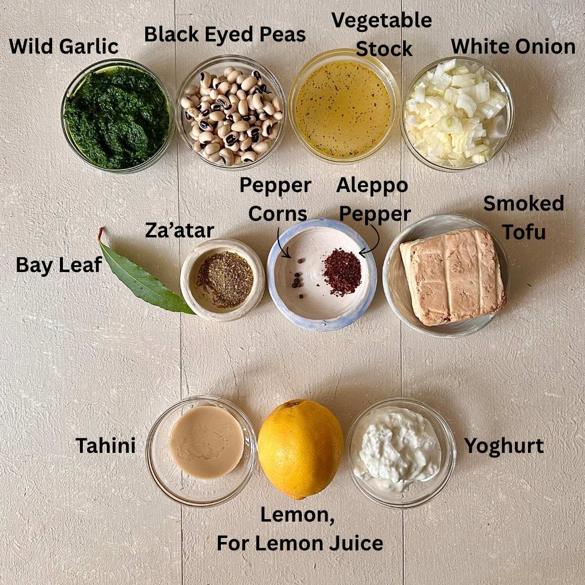 Prepared ingredients for black eyed peas with smoked tofu in small glass dishes. The ingredients are annotated.
