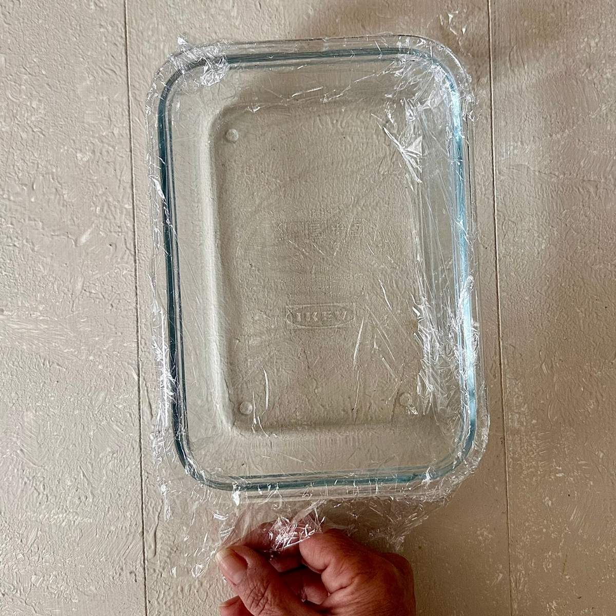 A rectangular glass dish lines with cling film. For flowering current jelly dessert.