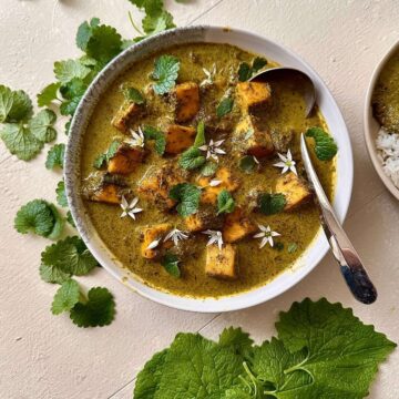 Overhead bowl of wild garlic curry with paneer and foraged greens.