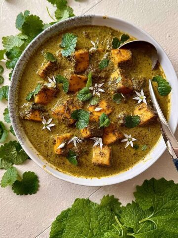 Overhead bowl of wild garlic curry with paneer and foraged greens.