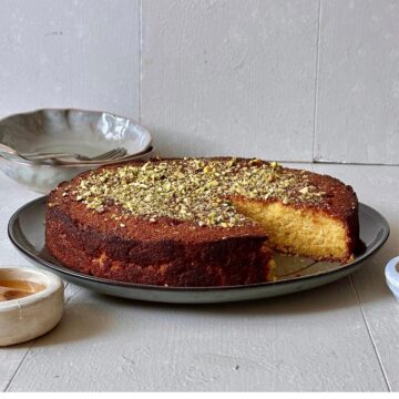 Orange almond polenta cake topped with chopped pistachios.