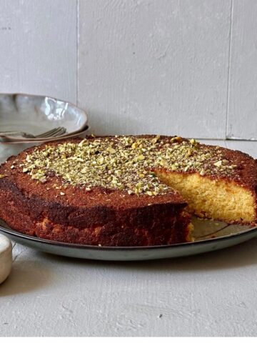 Orange almond polenta cake topped with chopped pistachios.