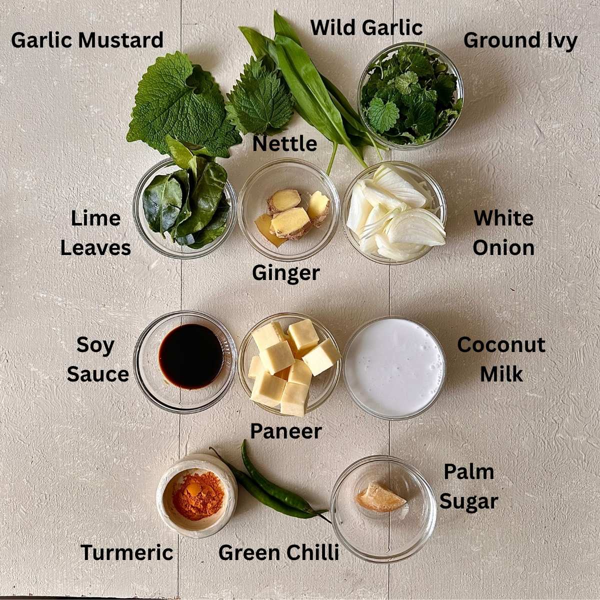 Ingredients for wild garlic curry in small glass dishes. Ingredients are annotated.