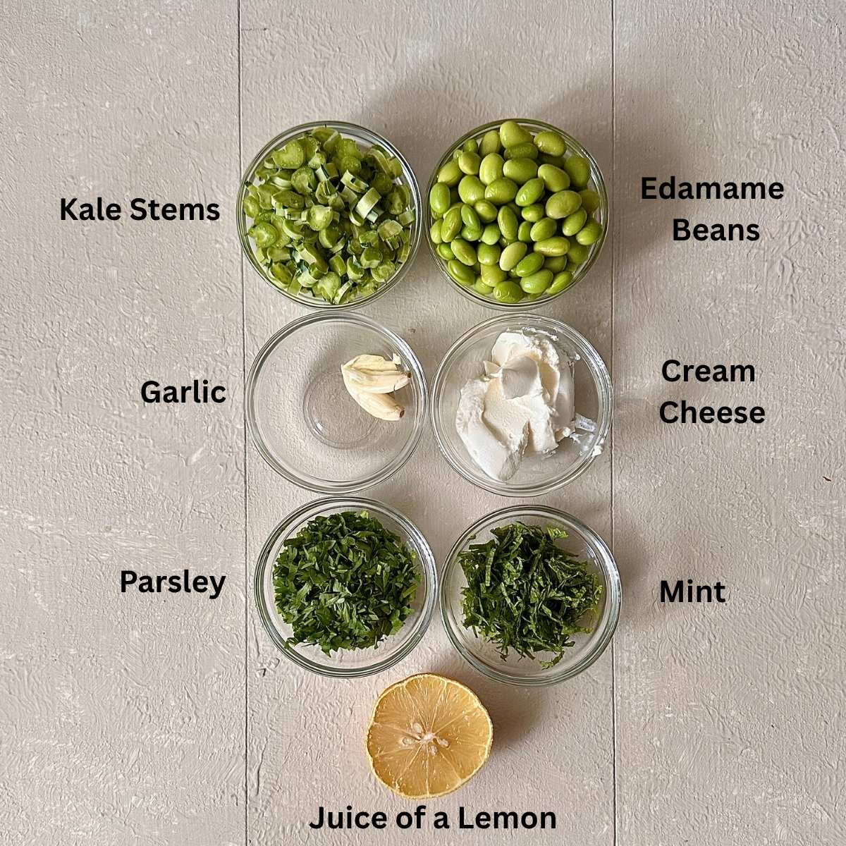 Prepared ingredients for smashed edamame toast in small glass dishes. The ingredients are annotated.
