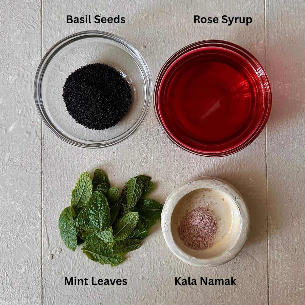 Ingredients for rose popsicles in small glass and ceramic dishes on a white background.
